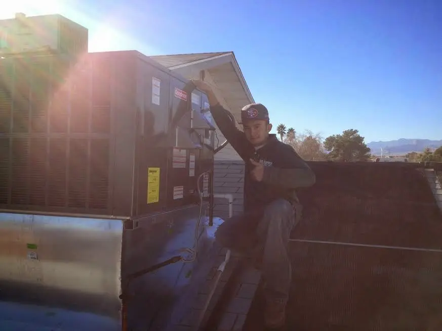 HVAC technician performing AC Tune-Up on a rooftop unit in Steubenville