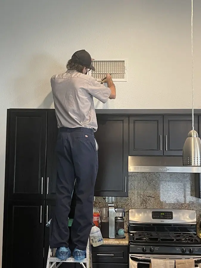 Technician inspecting an air vent during HVAC service in Steubenville